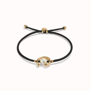 Pulsera de hilo negro con perla shell fornitura bañada en oro 18k.